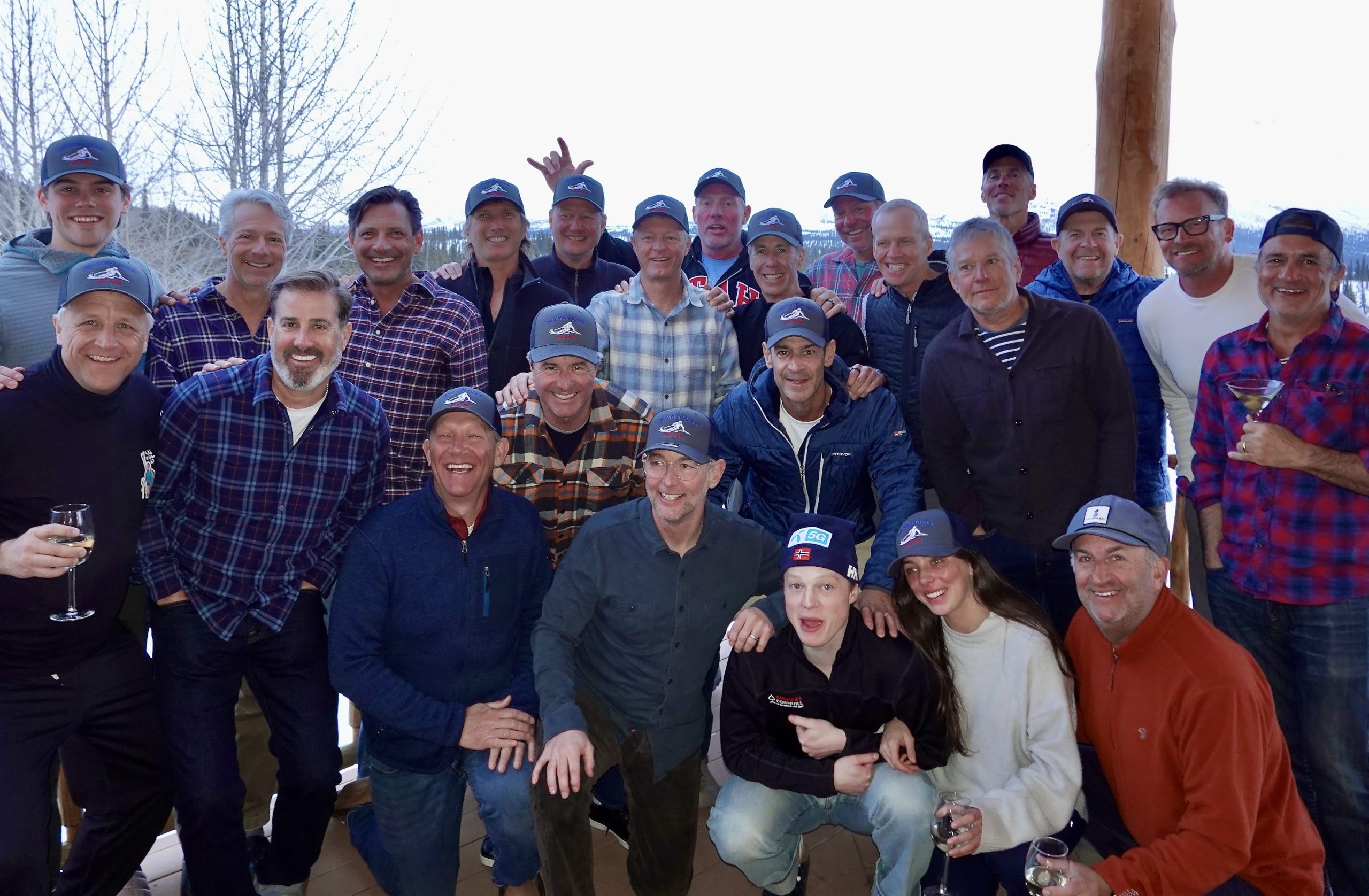 The birthday group, about two dozen friends in matching caps, at the Alaska lodge