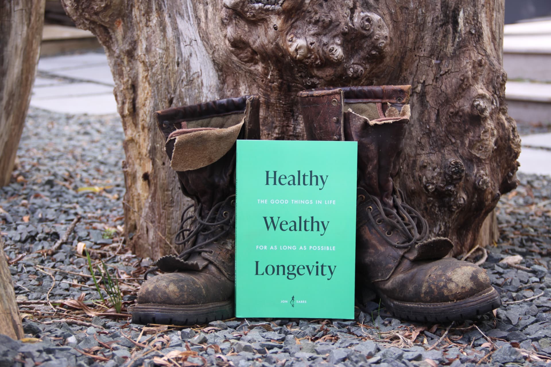 Healthy Wealthy Longevity standing between worn work boots