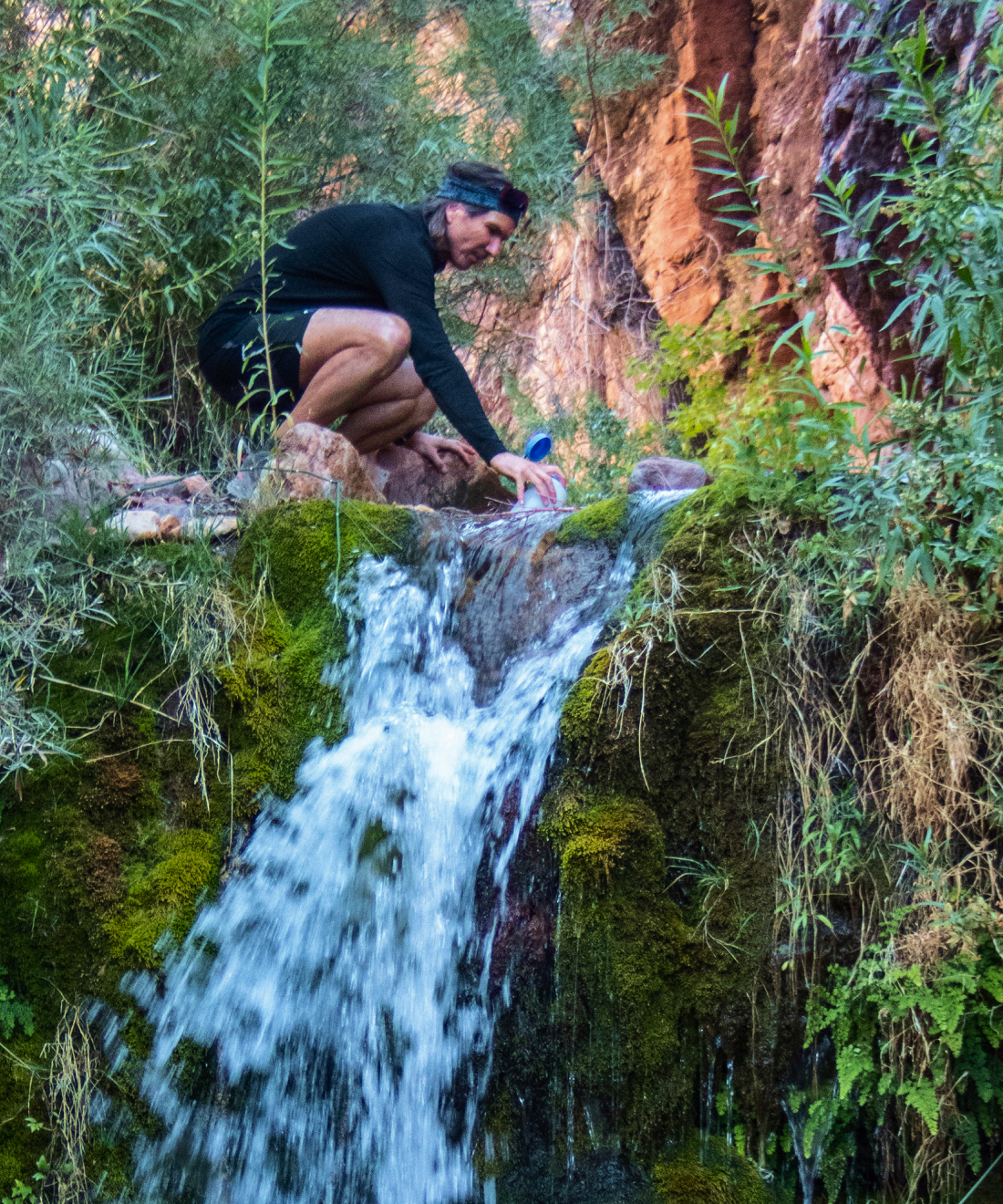 Jon Sabes beside a desert waterfall