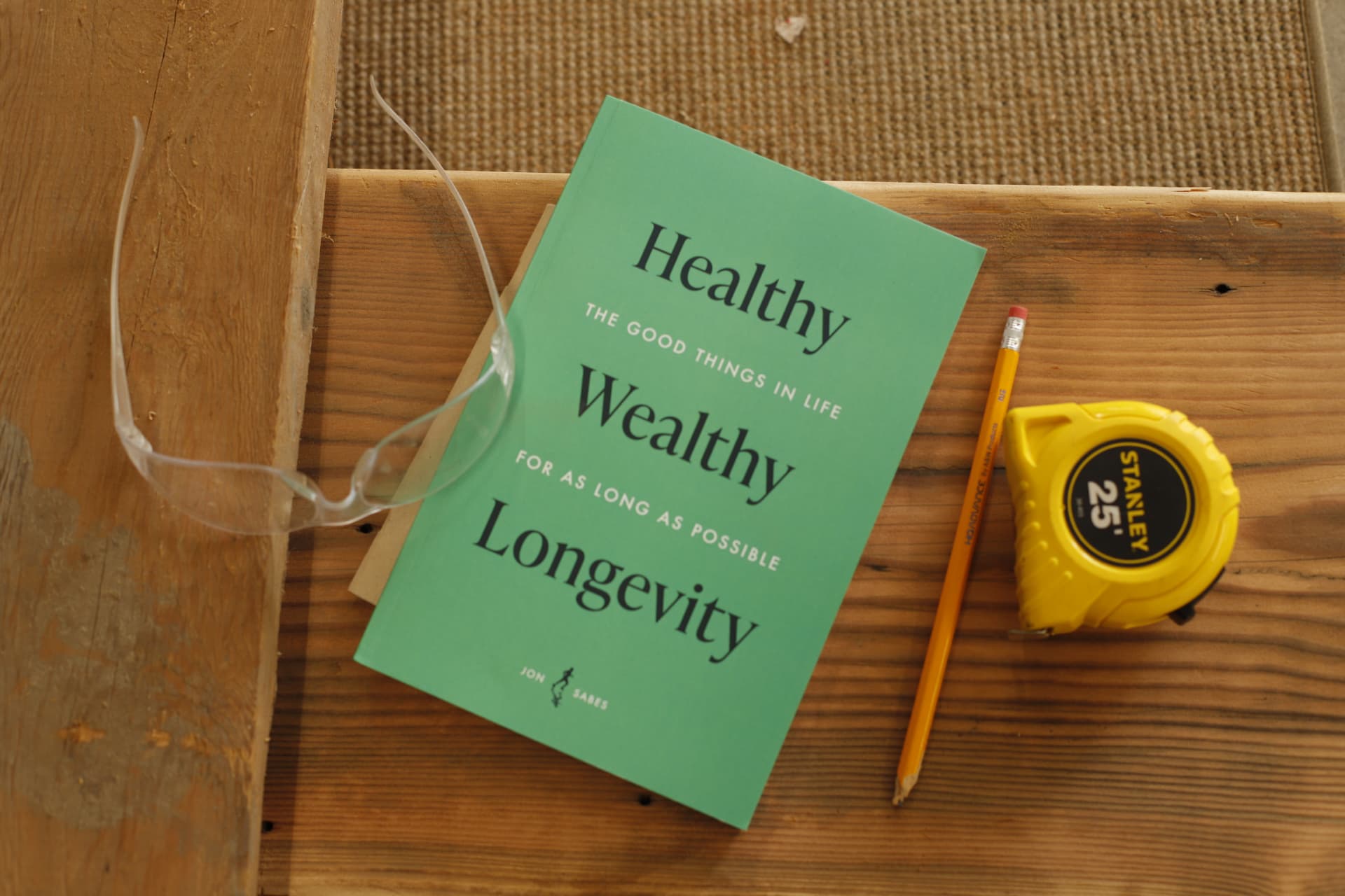 Healthy Wealthy Longevity on a workbench with a pencil and tape measure