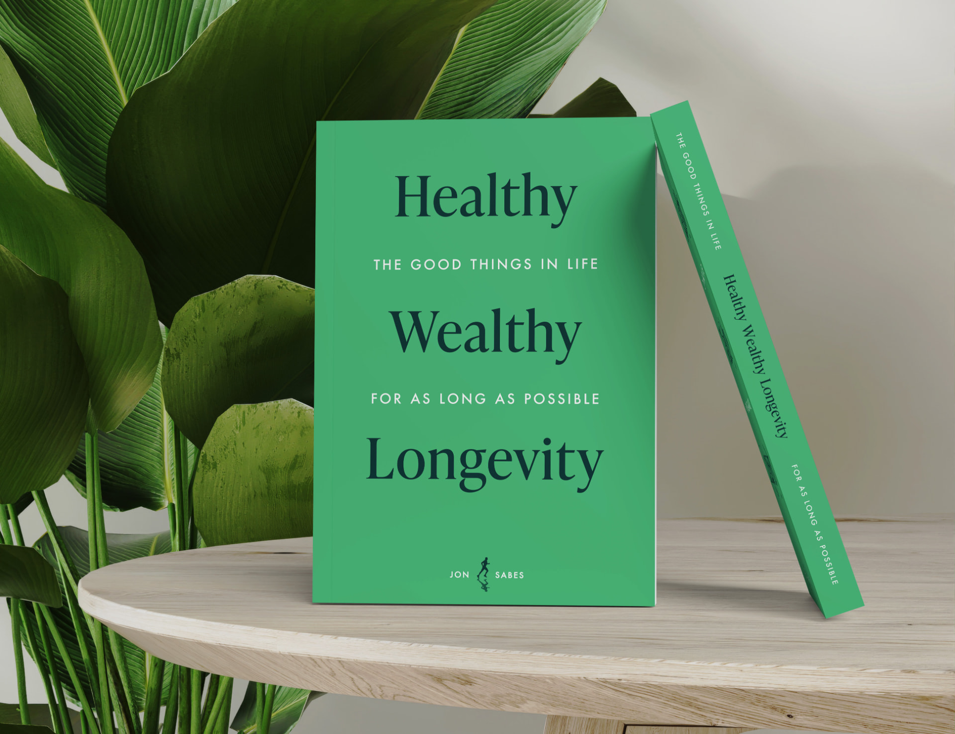 Healthy Wealthy Longevity on a table beside a plant